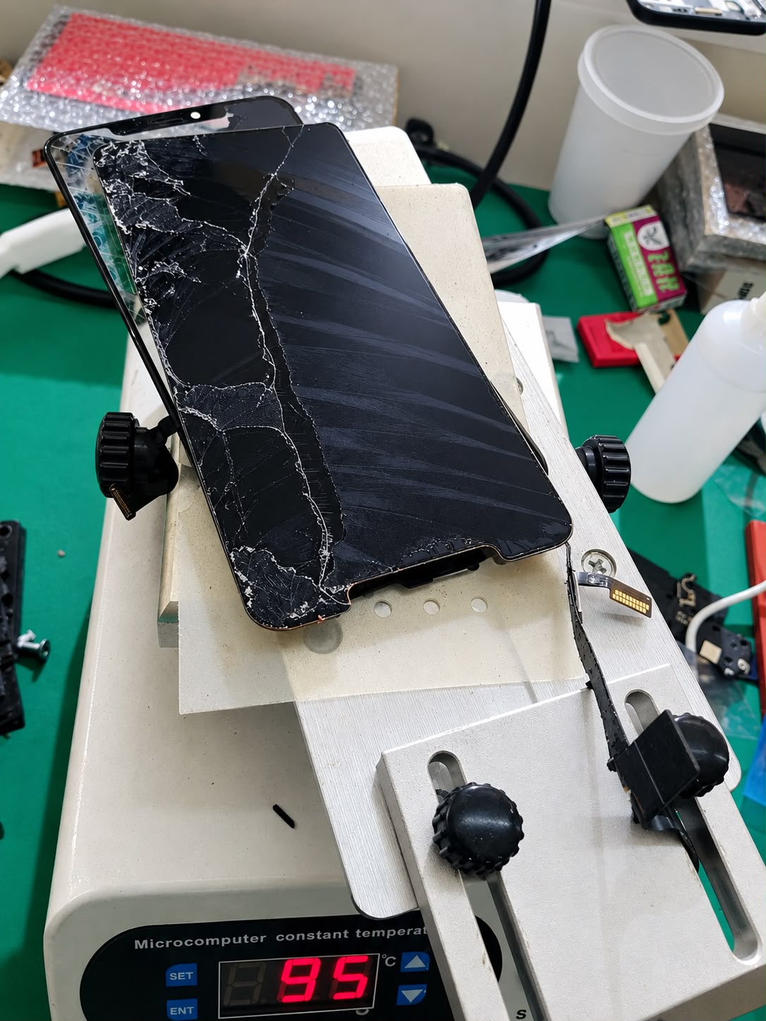 Pantalla de celular rota montada en un separador térmico durante la práctica de la capacitación