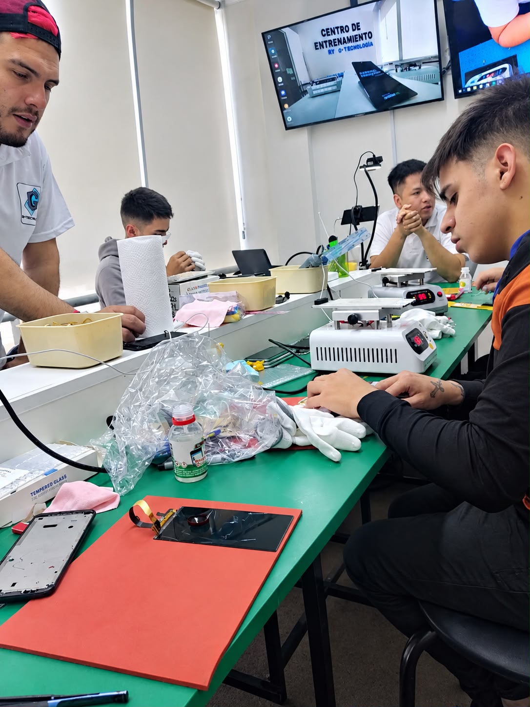 Grupo practicando reparación de pantallas en el Centro de Entrenamiento de la capacitación